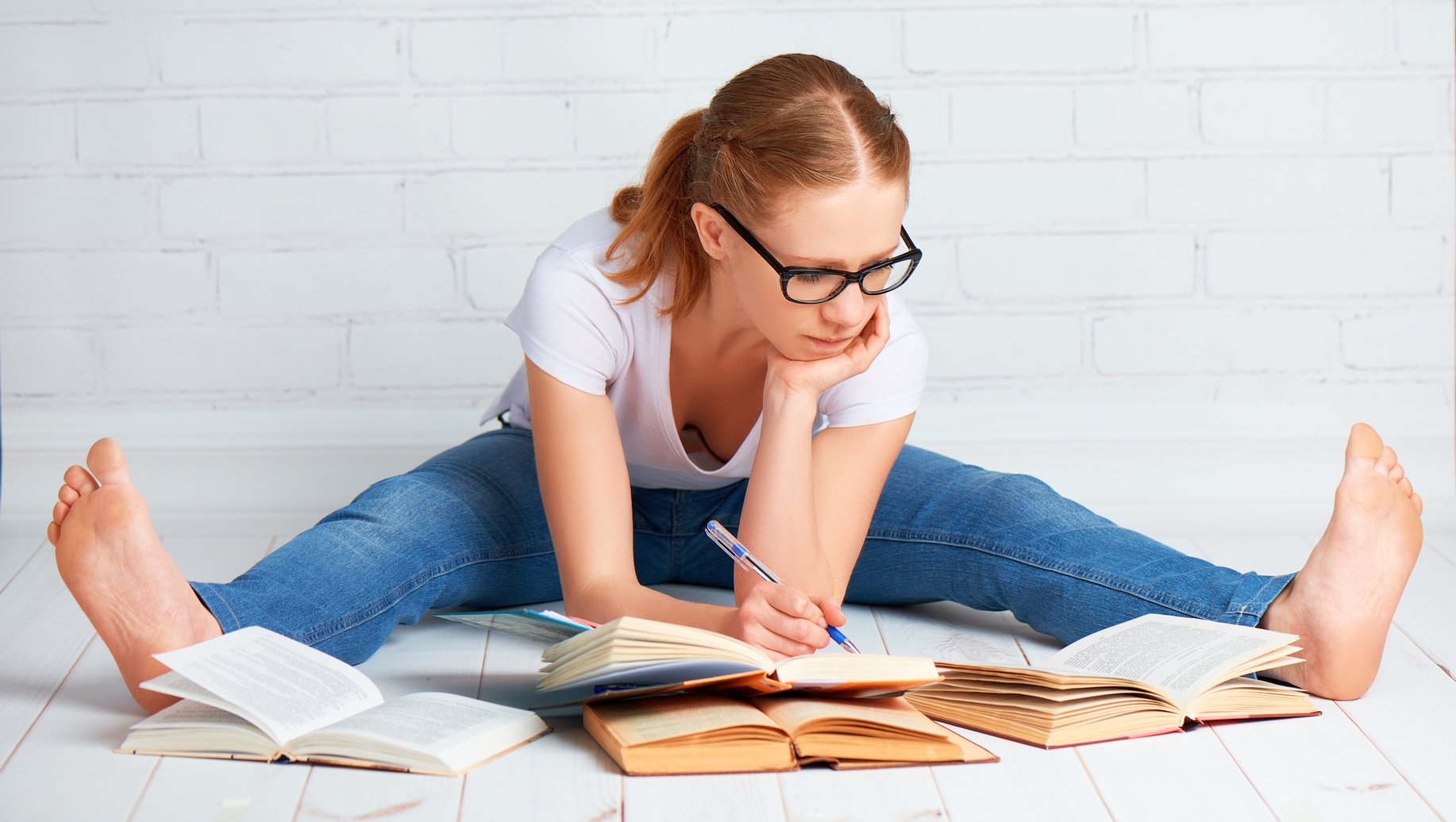 happy girl student preparing homework, preparing for the exam with books at home on the floor